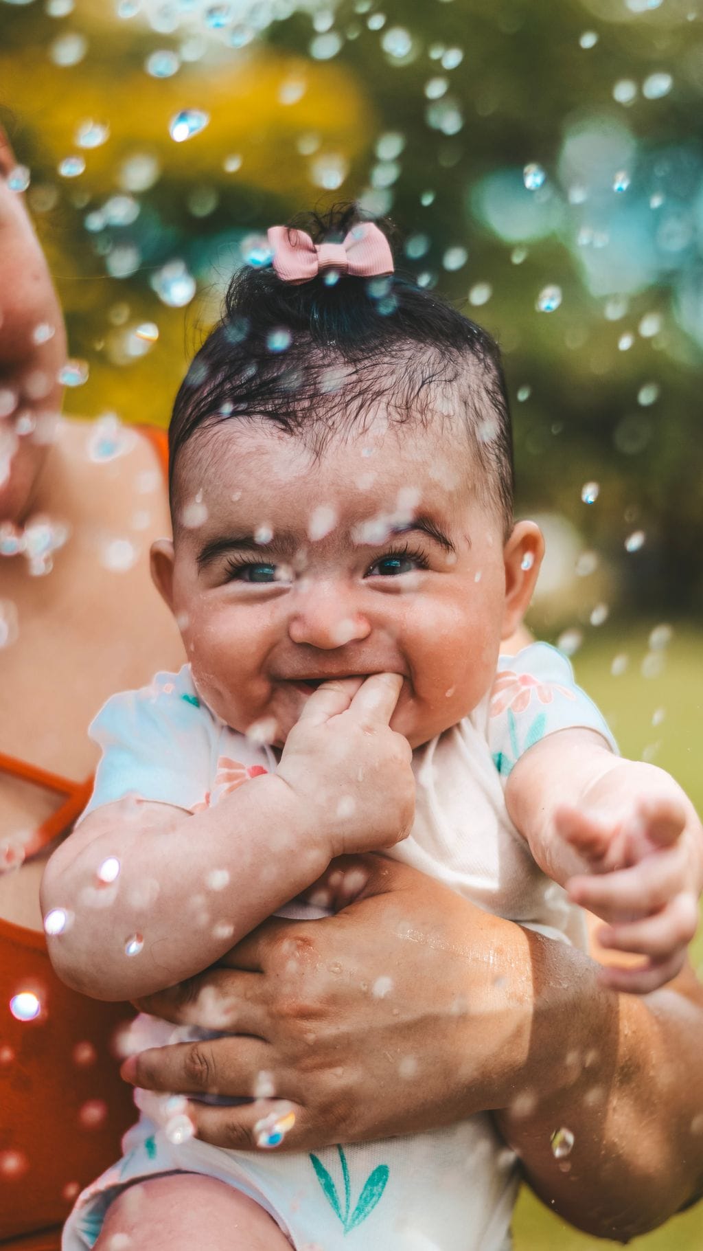 Minha filha sorrindo feliz sob bolhas de sabão