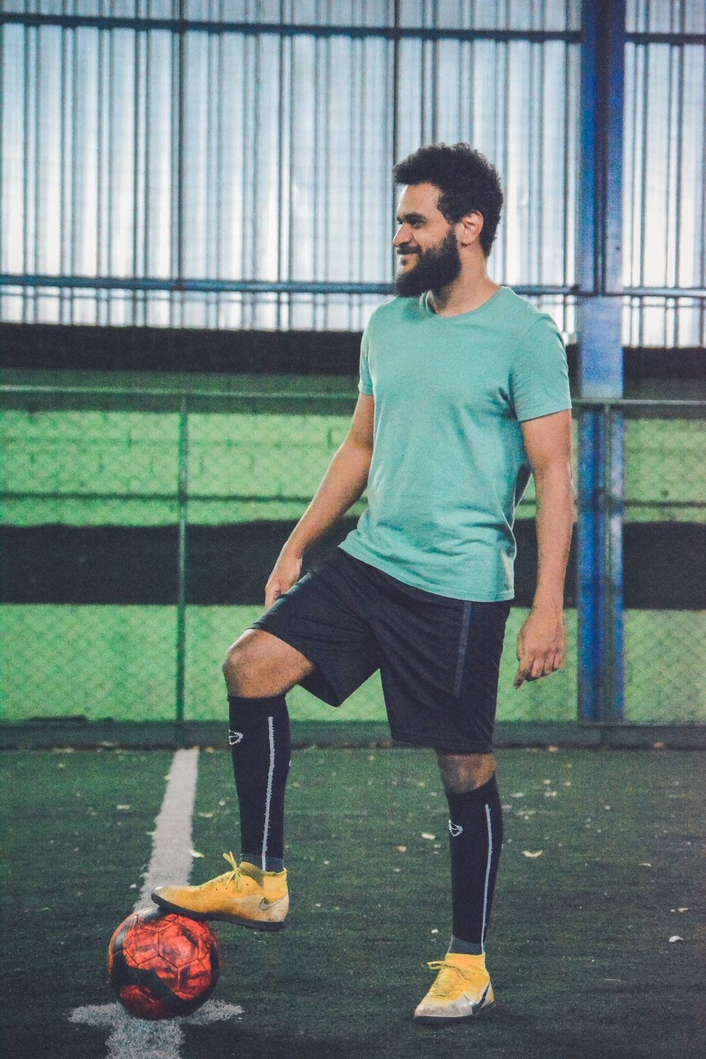 Claudemir posando em quadra de gramado sintético com bola de futebol sob o pé